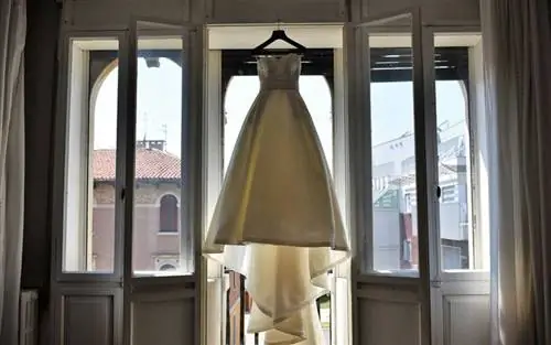 Свадебное платье висит у окна дома