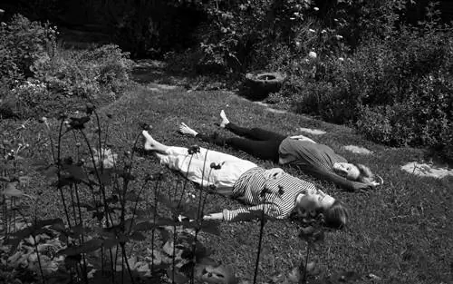 Фанни Сингер и Элис Уотерс лежат на траве в саду (черно-белое)