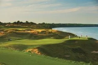 Поле для гольфа Whistling Straits Люди играют в гольф на закате