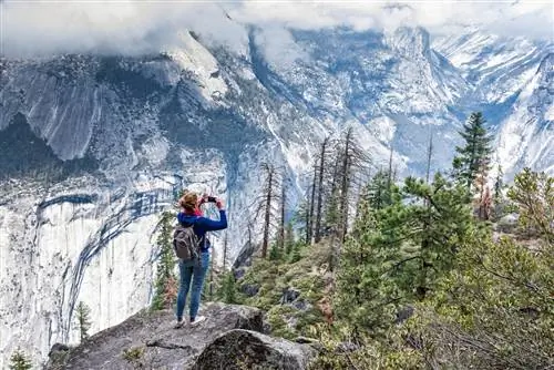 Девушка с маленьким рюкзаком фотографирует Йосемити
