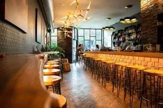 На изображении может находиться человек паб барная стойка кафе ресторан и мебель