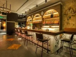 На этом изображении может находиться Мебель Стул Ресторан Паб Барная стойка Бутылка Напиток Алкоголь Напиток и вино