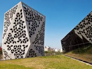 Это изображение может содержать траву, растение, здание, куст, растительность, треугольник, архитектуру, офисное здание и газон.