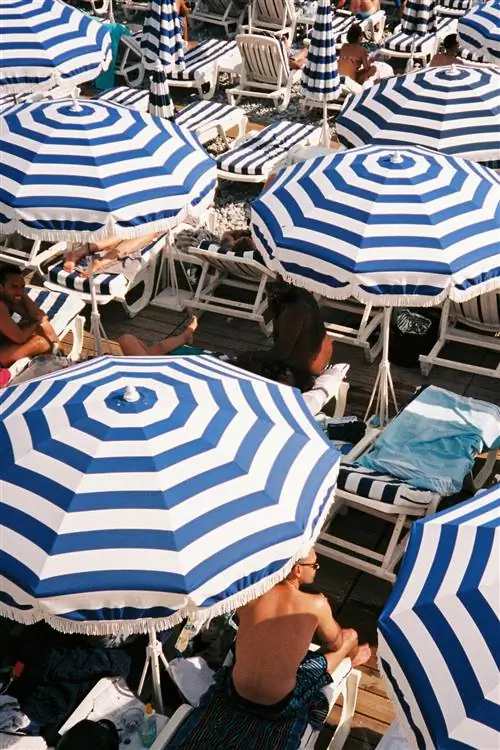 На изображении может находиться стул с зонтиком и ресторан, человеческий человек, мебель