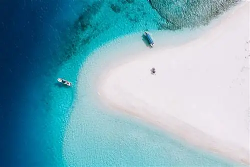 Аэрофотоснимок кораллового рифа с прозрачными голубыми тропическими водными лодками и зонтиками Национальный парк островов Керама Окинава Япония