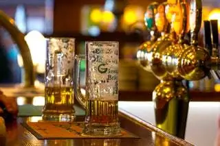 На изображении может находиться стакан напиток пиво пиво стакан алкоголь напиток лампа паб и барная стойка