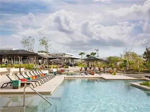 На изображении может находиться курортный отель, здание, бассейн, вода, человек и бассейн.