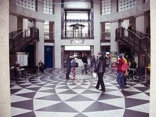 На изображении может находиться напольное покрытие человек человек пол перила перила пешеход в помещении вестибюль и комната