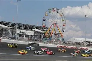 Гонщики мчатся возле колеса обозрения во время гонки Bank of America Roval 400 на гоночной трассе Charlotte Motor Speedway в Конкорде, Северная Каролина.