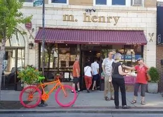 экстерьер m.henry. оранжевый и розовый велосипед. люди собираются и разговаривают