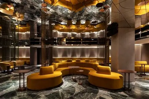 желтый диван с отражающим потолком и мраморным полом