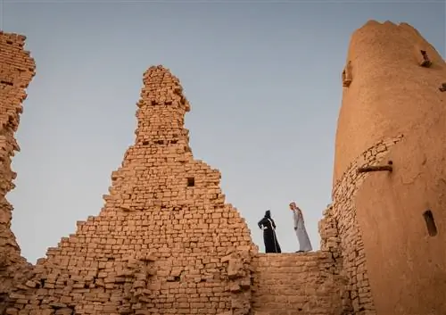 две фигуры, стоящие над руинами в пустыне