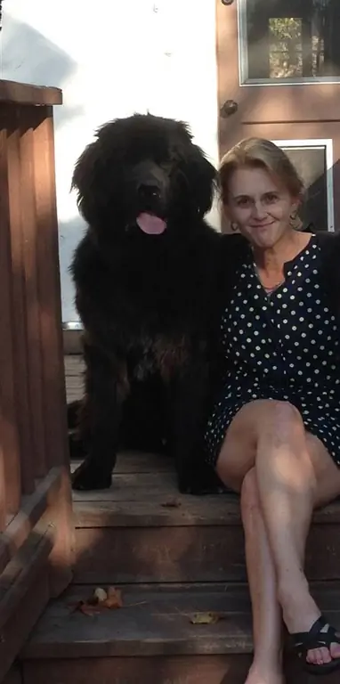 Это изображение может содержать человеческую одежду, одежду, животное, домашнее животное, собаку, млекопитающее, женское лицо, текстуру лица и дерево.