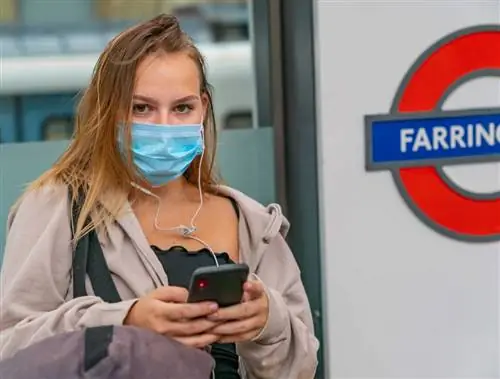 Женщина в маске на станции метро в Лондоне во время Covid 19