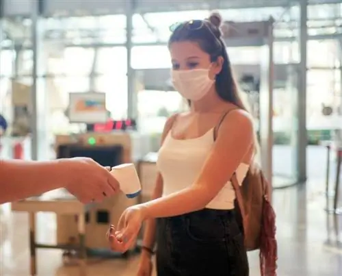 Девушка в маркировке температуры в аэропорту США