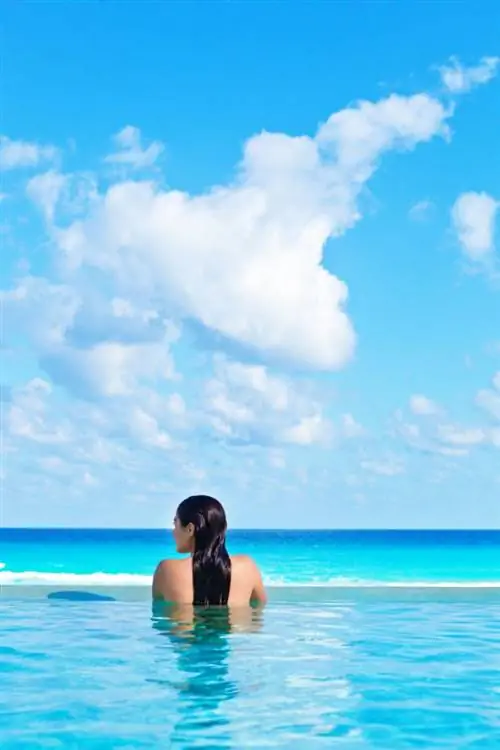 Женщина в бассейне с видом на океан в Канкуне, Мексика (1)