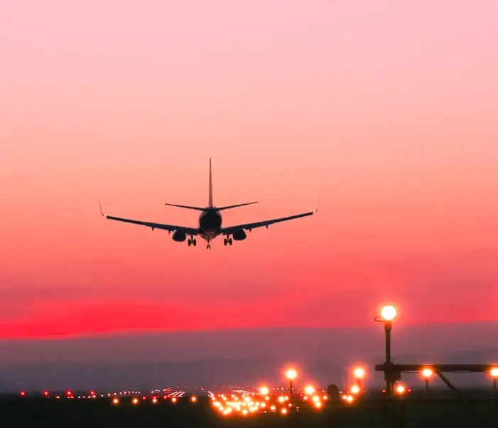 самолет приземляется на взлетно-посадочной полосе закат