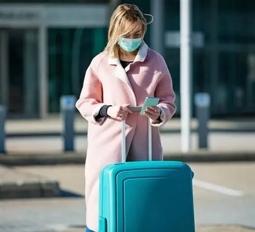 маска путешественника в аэропорту, чемодан