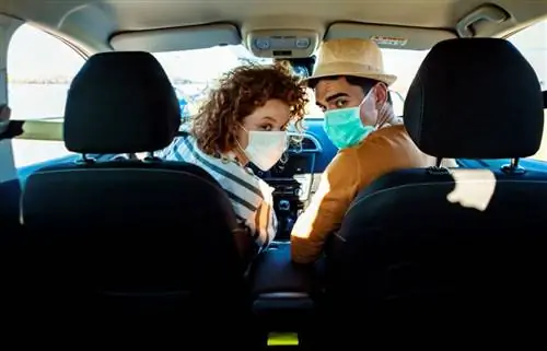 пара в масках едет в машине