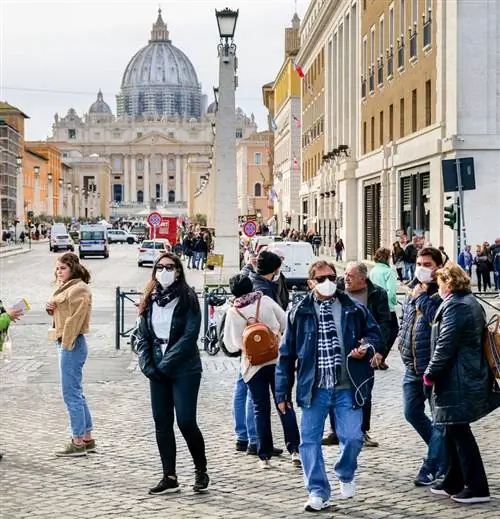 Группа туристов в масках возле площади Святого Петра, Рим, Италия