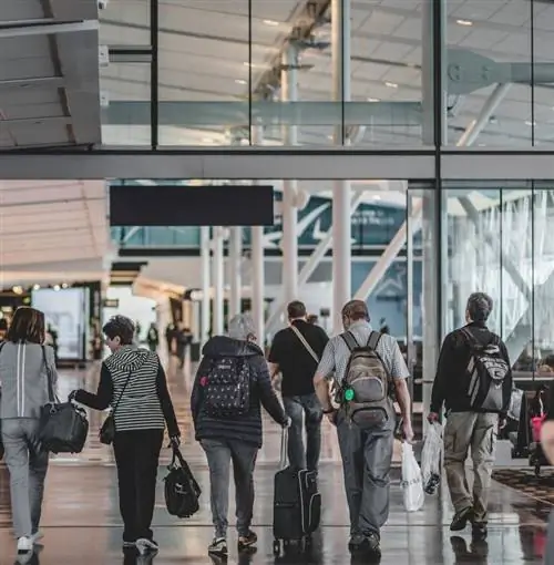 Путешественники, идущие в аэропорту с багажом