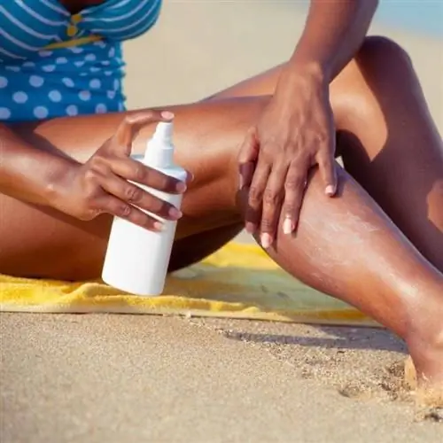 женщина с солнцезащитным кремом на пляже