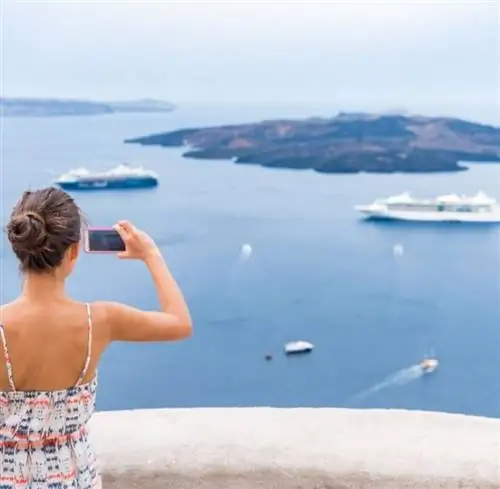 женщина фотографирует круизные лайнеры, плывущие вдалеке