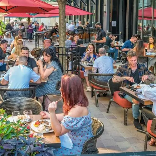 Люди обедают во внутреннем дворике ресторана в центре Торонто, Онтарио, Канада, солнечным вечером. С 22 сентября для обедов в помещении в Онтарио потребуется подтверждение вакцинации.