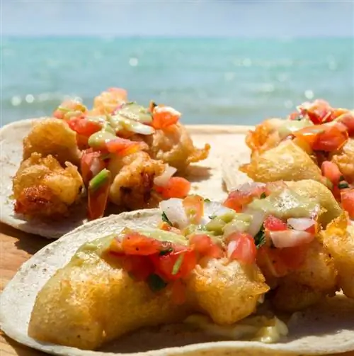 тарелка тако с креветками на пляже в Канкуне, Мексика