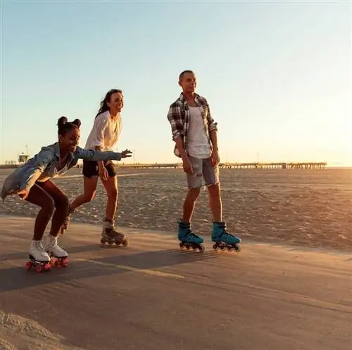 Друзья катаются на роликовых коньках на променаде в Венис-Бич - набережная Санта-Моники - Лос-Анджелес, США