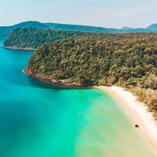 Длинный пустынный пляж с белым песком и прозрачной водой. Вид сверху с воздуха. Побережье острова Кох Ронг Самлоем, Камбоджа