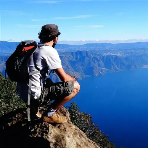 турист с рюкзаком на вершине вулкана Сан-Педро в Гватемале