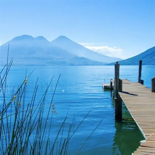 пустой деревянный пирс, ведущий к озеру Атитлан, Гватемала, Маунтин-Вью вдалеке