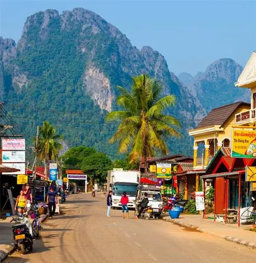 Район Ванг-Вьенг во Вьентьяне, Лаос, заполненный гостевыми домами. Можно увидеть автомобилистов, проезжающих и припарковавшихся на улице.