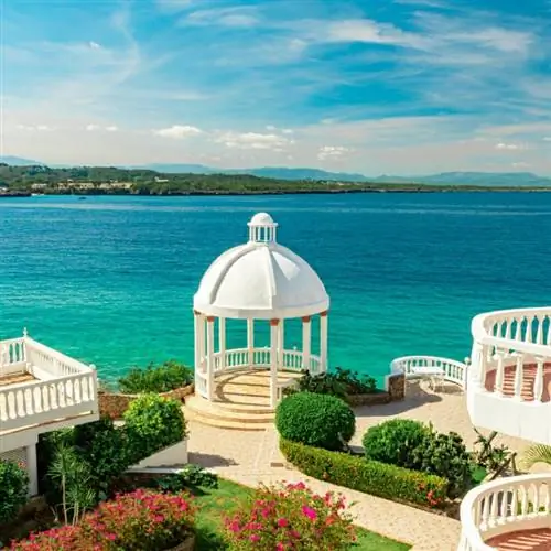 Красивая белая беседка и тропический цветочный сад на фоне Карибского океана, Сосуа, Пуэрто-Плата