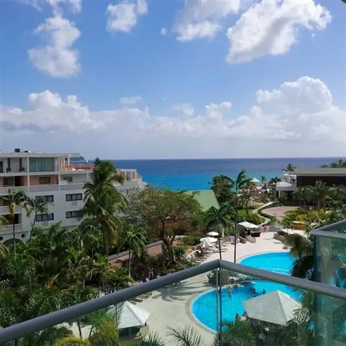 Вид на апартаменты курортного отеля Sonesta Maho Beach Resort. Красивое голубое небо и океан