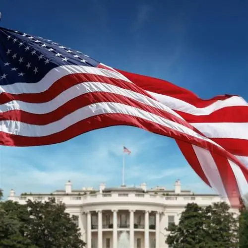 Флаг США развевается на фоне размытого Белого дома