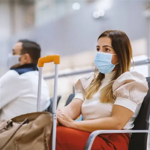 Молодая туристка в маске в аэропорту