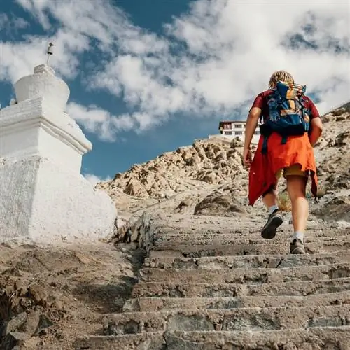 Турист-мужчина поднимается на тибетское святое место в Гималаях