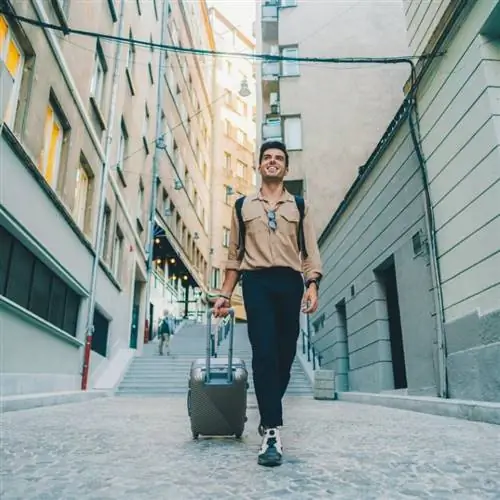 Молодой турист тащит багаж по улицам Софии, столицы Болгарии