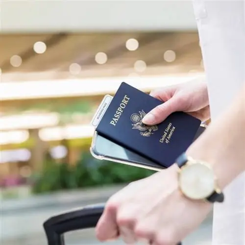 Женщина готовится к международному путешествию с паспортом и багажом США