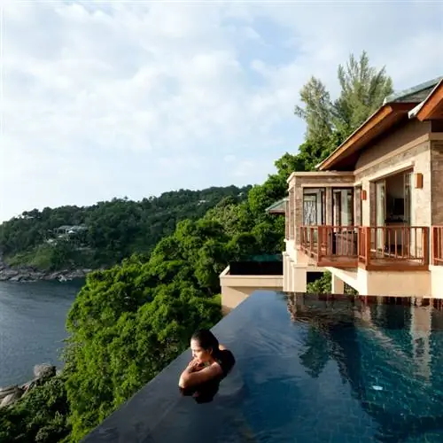 Женщина в пейзажном бассейне с видом на Пхукет, Таиланд