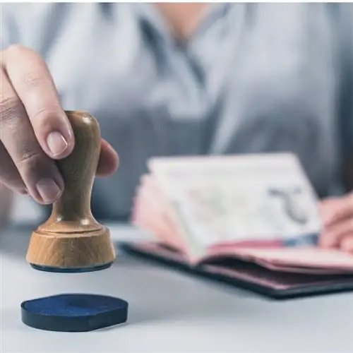 Иммиграционный и паспортный контроль в аэропорту. Женщина-сотрудник пограничного контроля ставит штампы в паспорте США