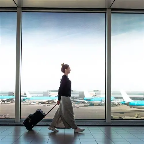 Женщина с чемоданом собирается сесть на следующий рейс