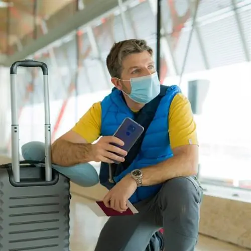 Молодой путешественник-мужчина ждет посадки на рейс в аэропорту