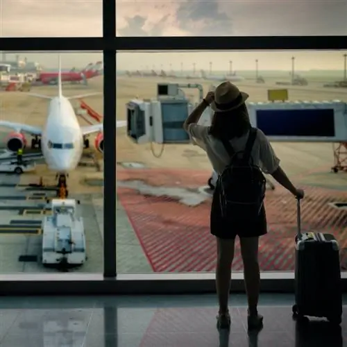 Путешественник, ожидающий посадки на рейс у выхода на посадку в аэропорту