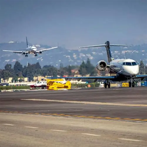 Два самолета готовятся к посадке и взлетают из оживленного аэропорта