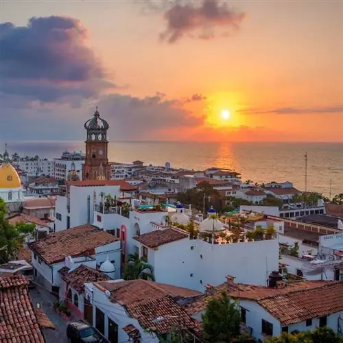 закат над городом в Пуэрто-Вальярта, Мексика