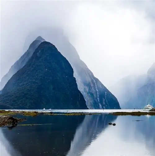 Земля хоббитов - Новая Зеландия. Порт туристических и прогулочных судов, яхт и катеров. Грозовые тучи закрывают небо над океанским фьордом Милфорд-Саунд. Концепция экзотического фототуризма.