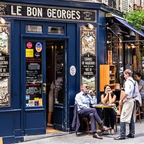Очаровательное кафе Le Bon Georges. Парижане и туристы наслаждаются едой и напитками в уличном французском кафе.